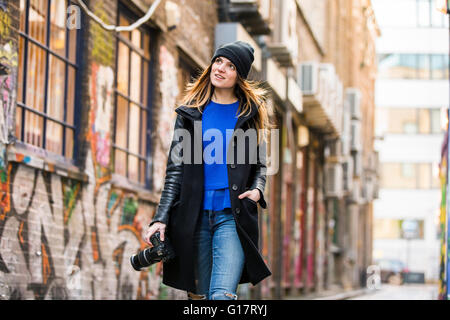 Junge weibliche Fotografin Graffiti Gasse schlendern Stockfoto