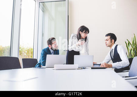 Geschäftsleute und Frau, die Sitzung am Konferenztisch Stockfoto