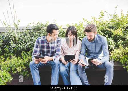 Drei Designer, die im Chat auf Büro-Dachterrasse Stockfoto