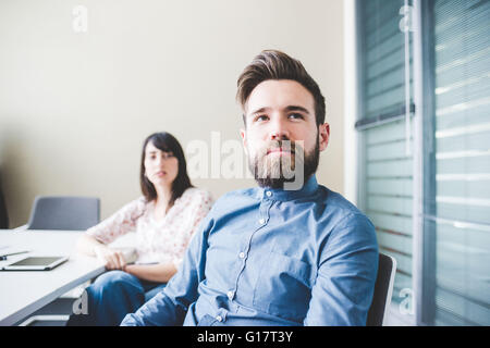 Zwei junge Designer in Vorstandssitzung zuhören Stockfoto