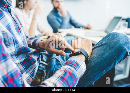 Schuss des jungen Designers Büro treffen Smartwatch mit abgeschnitten Stockfoto