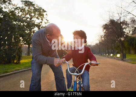 Großvater Lehre Enkel, im Park mit dem Fahrrad Stockfoto