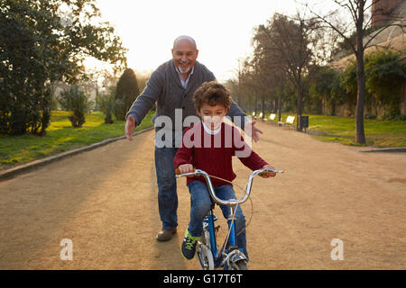 Großvater Lehre Enkel, im Park mit dem Fahrrad Stockfoto