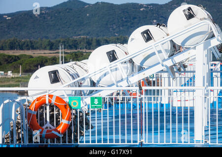 Aufblasbare Rettungsinseln in hartschaligen weißen Container und roten Rettungsring Geländer hängen. Moderne Pkw Schiff Sicherheit Ausrüstu Stockfoto