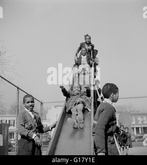 Kinder auf Folie während der Erholung am Gymnasium, Washington DC, USA, Marjorie Collins für Farm Security Administration, März 1942 Stockfoto