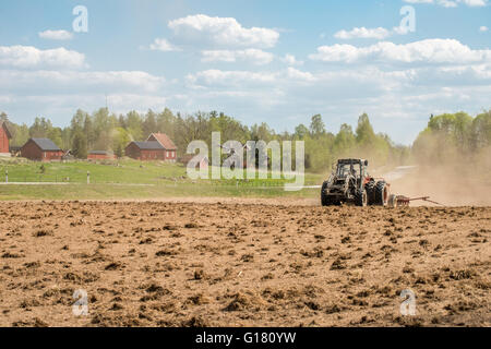 Traktor Pflügen der Felder im Frühling in Östergötland Grafschaft, Schweden. Stockfoto