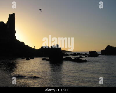 Sonnenuntergang hinter Dunure Burg Ruinen, Ayrshire, Schottland im winter Stockfoto