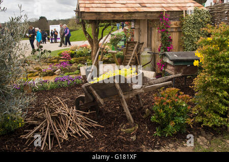 Besucher in Harrogate Spring Flower Show 2016 (North Yorkshire, England) übergeben einen rustikalen Schuppen und natürliche Bepflanzung im "Tierparadies" Schaugarten. Stockfoto