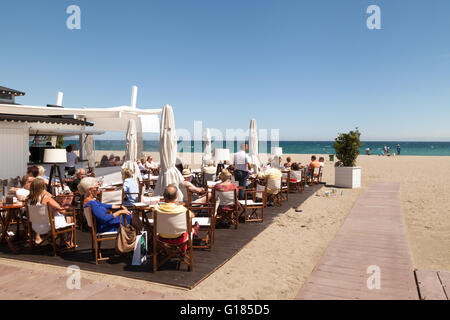 Menschen trinken am Strandcafé, Playa de Puerto Banus, Puerto Banus, Marbella, Spanien Europa Stockfoto