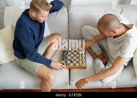 Vogelperspektive Ansicht der Männer auf Sofa spielen Schach lächelnd Stockfoto