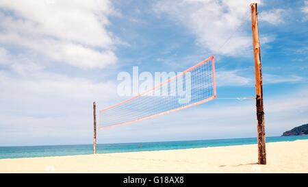 Volleyballnetz am leeren Sandstrand mit blauem Himmel Stockfoto