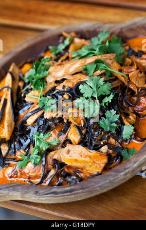 Thunfisch, Tomatensauce, Tinte Nudeln und Petersilie auf einem Teller Stockfoto