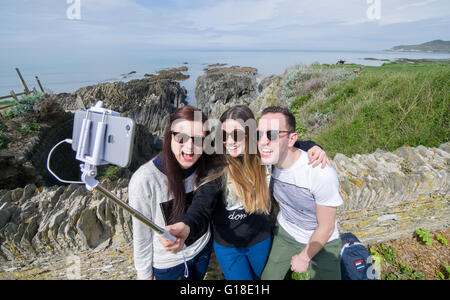 Urlaubern April Alder, Anna Volley und David Alder genießen das warme Wetter, wobei ein Selbstporträt in Woolacombe, Devon, UK Stockfoto