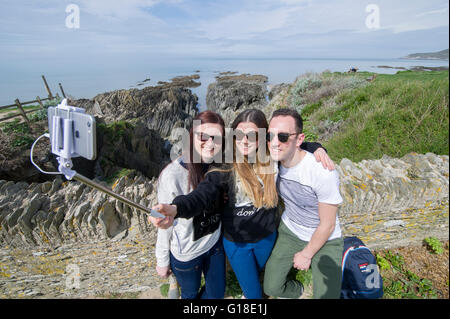 Urlaubern April Alder, Anna Volley und David Alder genießen das warme Wetter, wobei ein Selbstporträt in Woolacombe, Devon, UK Stockfoto