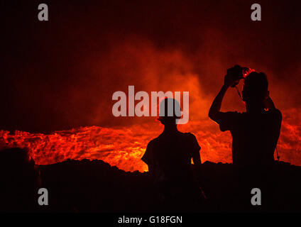 Touristen fotografieren vor dem lebendigen Lavasee im Krater des Vulkans Erta Ale, Afar-Region, Erta Ale, Äthiopien Stockfoto