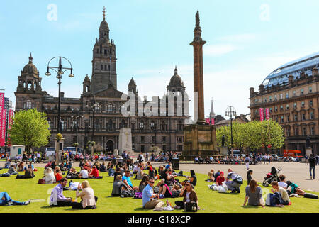 Glasgow, Vereinigtes Königreich. 11. Mai 2016. Viele Büroangestellte nehmen Sie sich Zeit zum Entspannen in ihrer Mittagspause und ein wenig Sonnenschein in das warme Frühlingswetter bei hohen Temperaturen in George Square, Glasgow Credit: Findlay/Alamy Live News Stockfoto