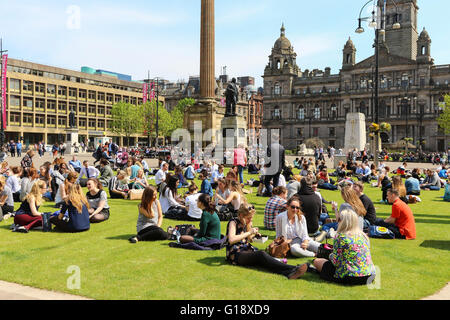 Glasgow, Vereinigtes Königreich. 11. Mai 2016. Viele Büroangestellte nehmen Sie sich Zeit zum Entspannen in ihrer Mittagspause und ein wenig Sonnenschein in das warme Frühlingswetter bei hohen Temperaturen in George Square, Glasgow Credit: Findlay/Alamy Live News Stockfoto