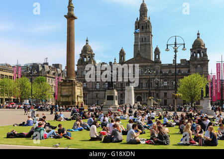 Glasgow, Vereinigtes Königreich. 11. Mai 2016. Viele Büroangestellte nehmen Sie sich Zeit zum Entspannen in ihrer Mittagspause und ein wenig Sonnenschein in das warme Frühlingswetter bei hohen Temperaturen in George Square, Glasgow Credit: Findlay/Alamy Live News Stockfoto