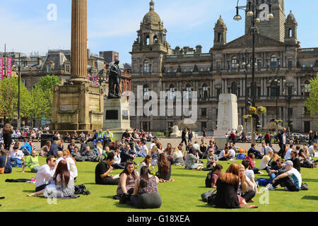 Glasgow, Vereinigtes Königreich. 11. Mai 2016. Viele Büroangestellte nehmen Sie sich Zeit zum Entspannen in ihrer Mittagspause und ein wenig Sonnenschein in das warme Frühlingswetter bei hohen Temperaturen in George Square, Glasgow Credit: Findlay/Alamy Live News Stockfoto