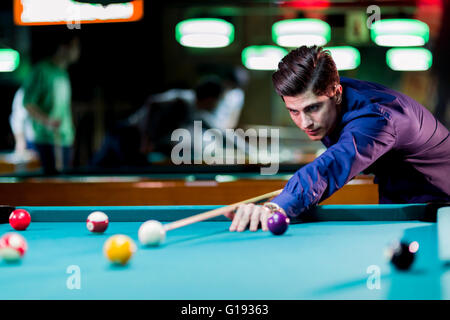 Schönen jungen Mann beugte sich über den Tisch beim Snooker spielen Stockfoto