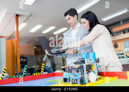 Zwei intelligente Studenten, die Programmierung eines Roboters auf einem laptop Stockfoto