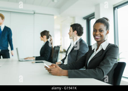 Junge Geschäftsleute sitzen an einem Konferenztisch beim Anhören der Dozent und neue Lerntechnologien und mit einem Stockfoto