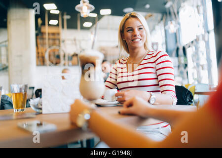 Schöne Frauen, Kaffeetrinken und tratschen in netten restaurant Stockfoto