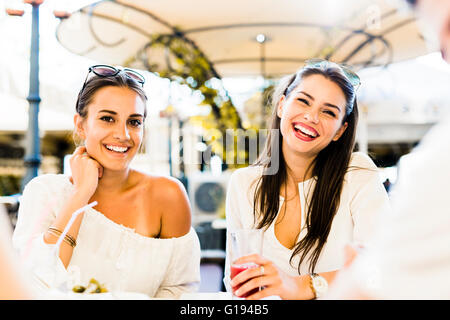 Zwei junge Mädchen sprechen und Lächeln während der Mittagspause Stockfoto