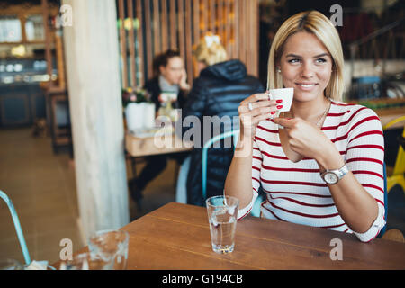 Schöne Frau in einem hölzernen Café Kaffee trinken Stockfoto