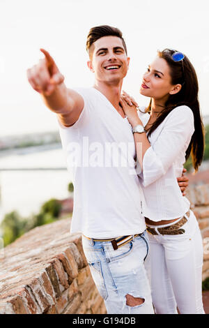 Glückliches Paar in eine Richtung zeigen und lächelnd Stockfoto