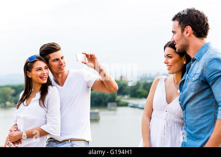 Junge und schöne Paare fotografieren mit smartphone Stockfoto