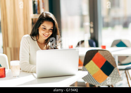 Schöne Brünette mit Laptop im café Stockfoto