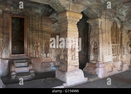 Höhle 4: Innenansicht. Die Figur des Mahavira in den Sanctu ist teilweise gesehen. Jaina Tirthankara Bilder eingraviert auf den Säulen Stockfoto