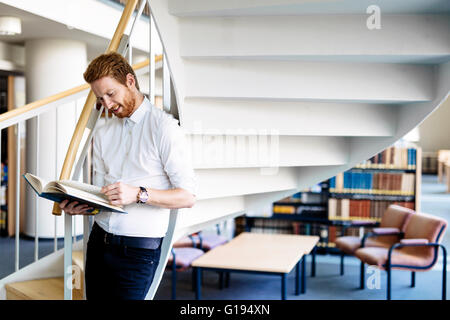 Hübscher Kerl ein Buch in einer Bibliothek Stockfoto