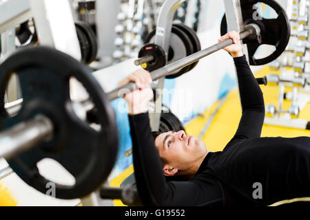 Nahaufnahme von jungen hübschen männlichen Übungen auf beim Bankdrücken Stockfoto