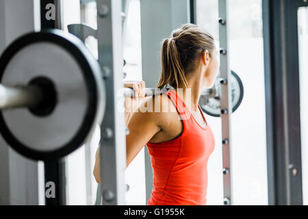 Junge schöne Frau, Gewichte zu heben, in ein Fitness-Studio konzentriert Stockfoto