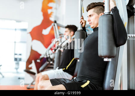 Zwei schöne Männer, die in einem schönen Fitnesscenter trainieren Stockfoto