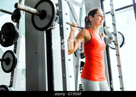 Junge schöne Frau, Gewichte zu heben, in ein Fitness-Studio konzentriert Stockfoto