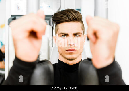 Porträt eines schönen Jünglings training in einem Fitnessstudio und mit Blick auf die Kamera Stockfoto