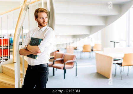 Hübscher Kerl ein Buch in einer Bibliothek Stockfoto