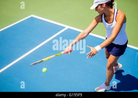 Schöne weibliche Tennisspieler in Aktion, schlagen eine Vorhand Stockfoto