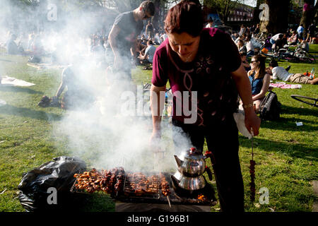 Hackney. London Felder Park. Sonntag Nachmittag in der Sonne. eine türkische Familie cook Kebabs und Tee auf einem Grill. Stockfoto