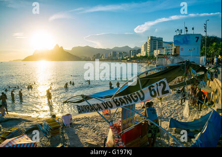 RIO DE JANEIRO - 21. Februar 2016: Massen von Menschen säumen den Strand Arpoador Ende von Ipanema, den Sonnenuntergang zu genießen. Stockfoto