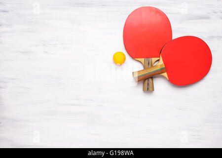 Zwei Tischtennis-Schläger auf einem weißen Holztisch. Draufsicht des Ping-Pong Paddel. Wettbewerb-Konzept. Stockfoto