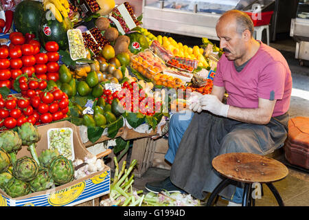 Standinhaber sitzen neben Obst und Gemüse stand, Istanbul, Türkei Stockfoto