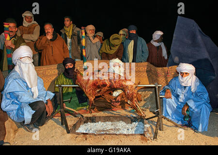 Tuareg, die Vorbereitung einer Lammbraten gegrillt in TAFSIT Festival. Algerien, Sahara, Hoggar (Ahaggar Berge), Tamanrasset Stockfoto