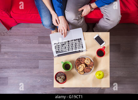 Junges Paar mit Laptop auf couch Stockfoto