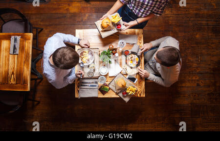 Junge Männer beim Mittagessen in einem Café, Ansicht von oben Stockfoto