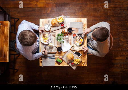 Junge Männer im Café oder im Restaurant Essen Stockfoto