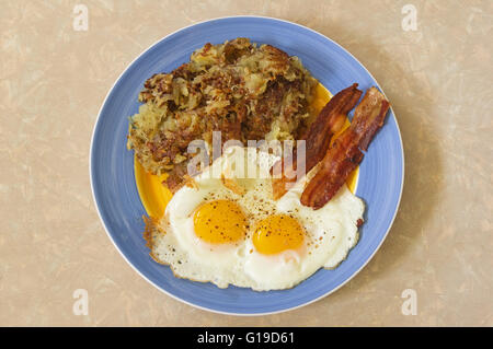 herzhaftes Frühstücksteller mit Hash browns, zwei Eiern und Speck Stockfoto